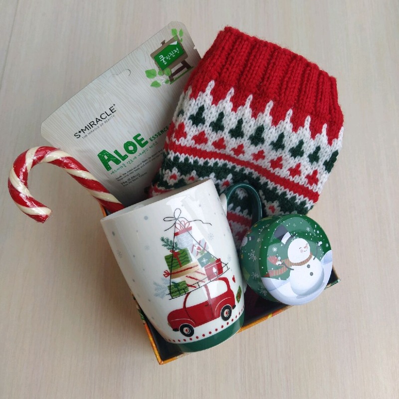 Подарок маме в новогодней коробке с вязаными носками, кружкой и леденцом