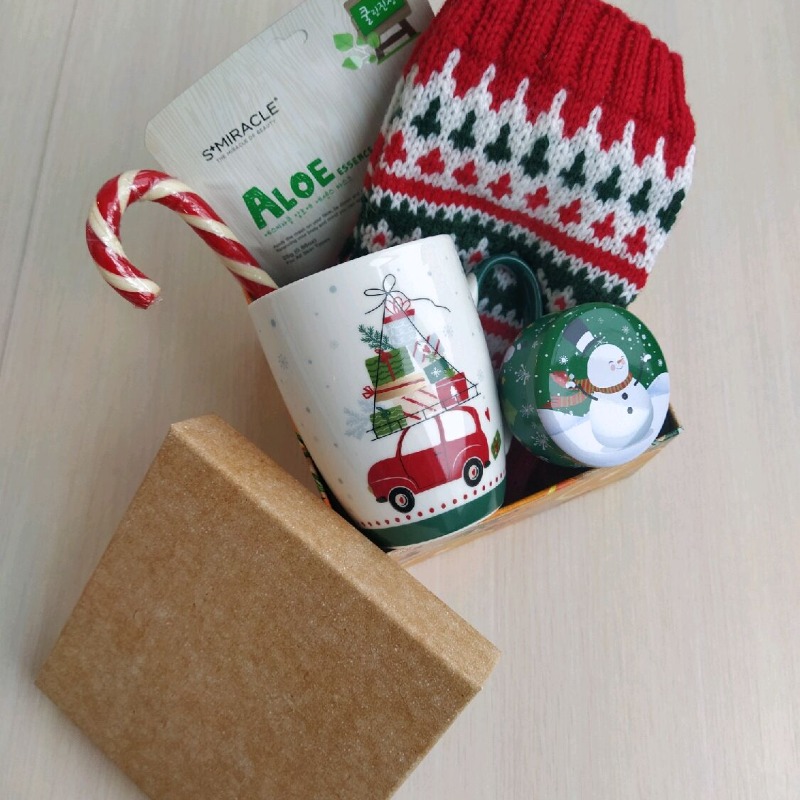 Подарок маме в новогодней коробке с вязаными носками, кружкой и леденцом